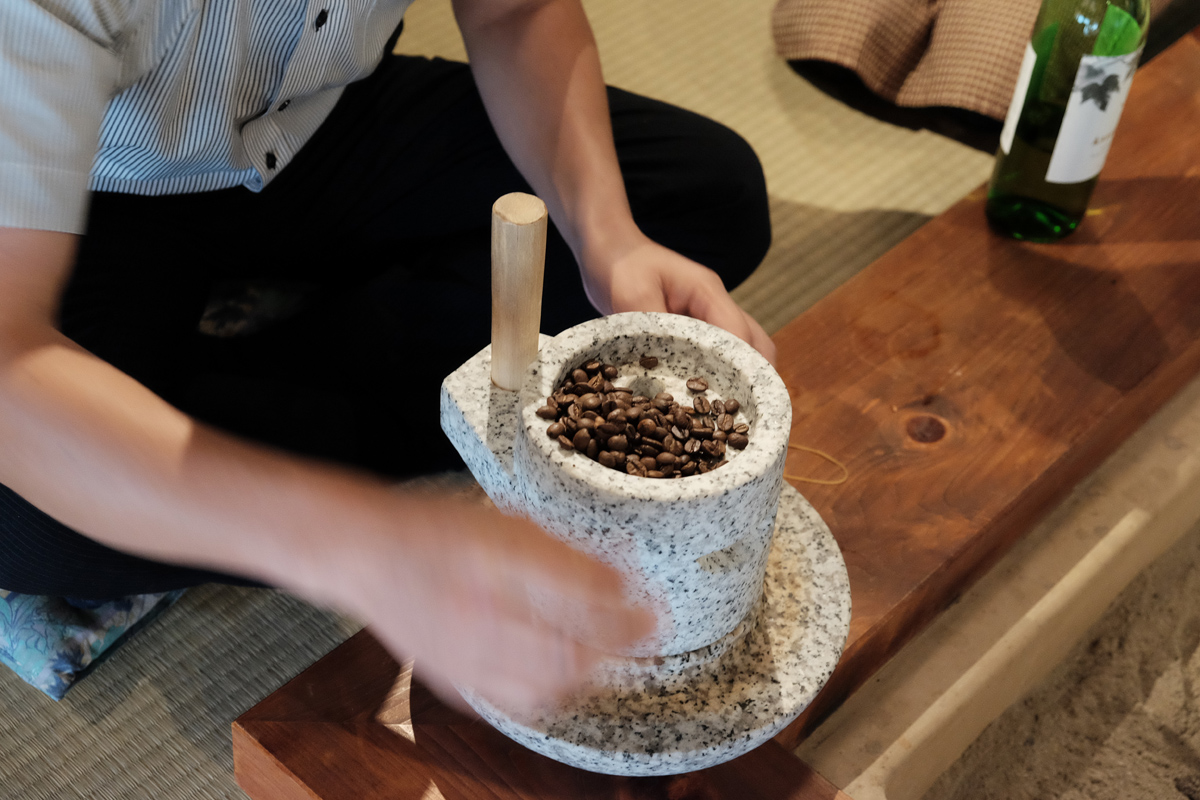 石臼でコーヒー豆を挽く
